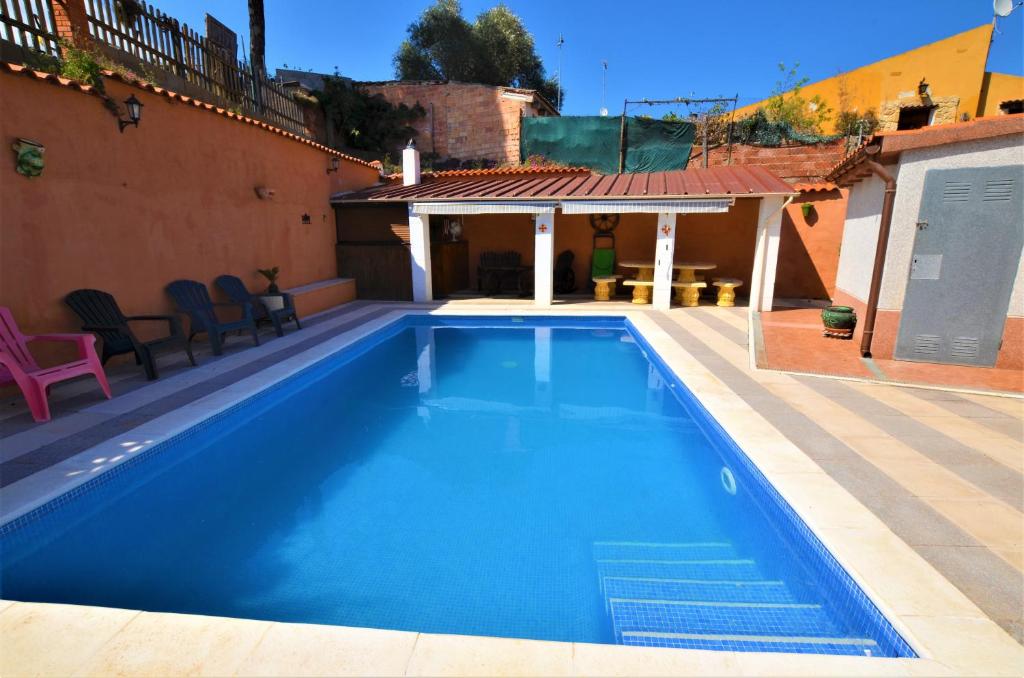 a large blue swimming pool next to a house at Villa Olombel in Maçanet de la Selva
