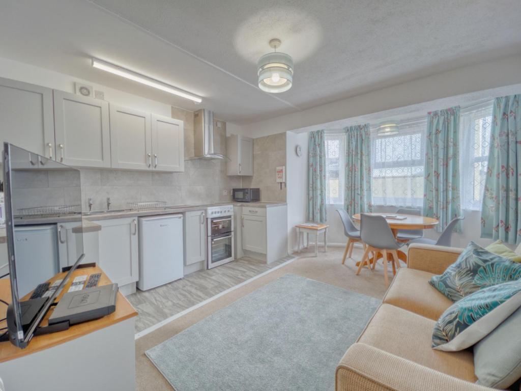 a kitchen and living room with a couch and a table at Apartment 7 - 1 bedroom Sea front location - Step free access from rear - Free Parking in Paignton