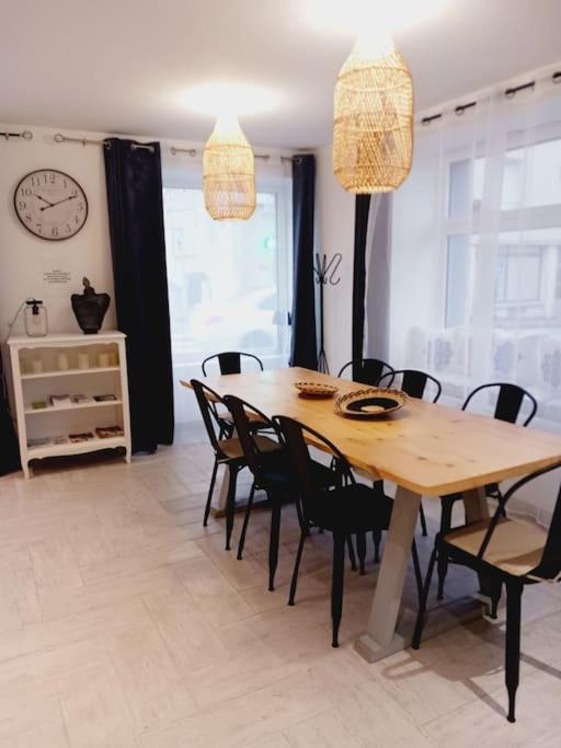 a dining room with a wooden table and chairs at maison spacieuse centre et plage in Brest