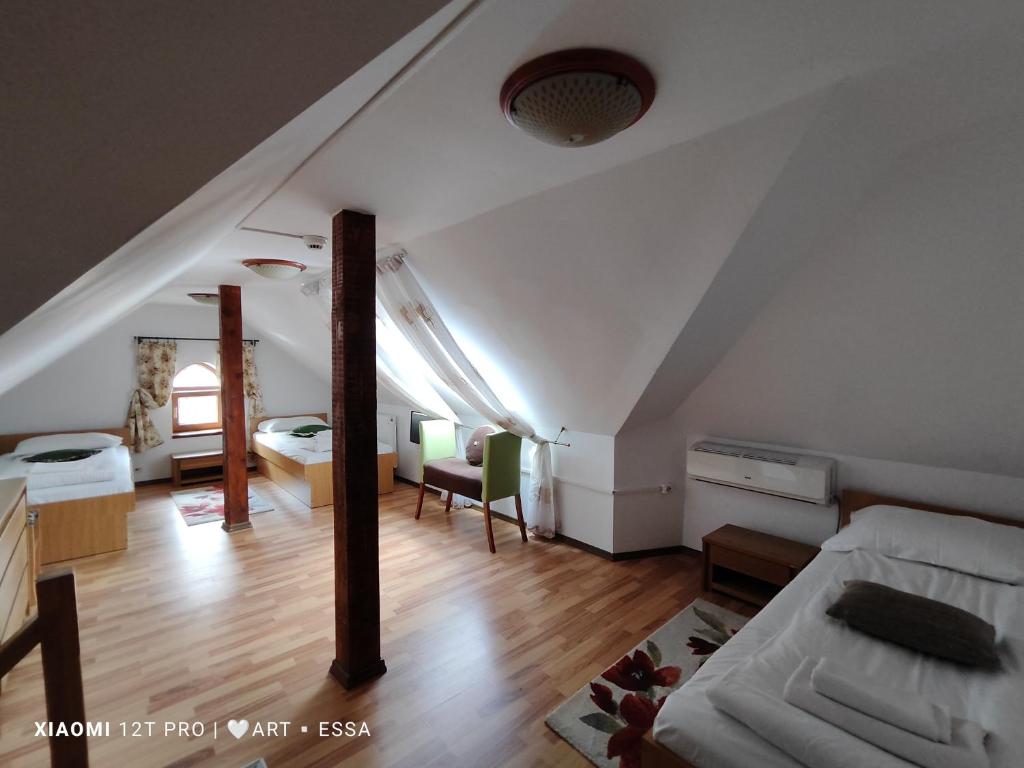 a attic room with a bed and a bedroom at Pensiunea Buon Gusto Sibiu-motorcyle friendly,city center in Sibiu