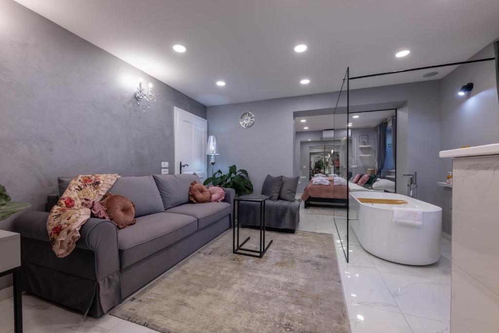 uma sala de estar com um sofá e uma banheira em MM estetika rooms em Bled