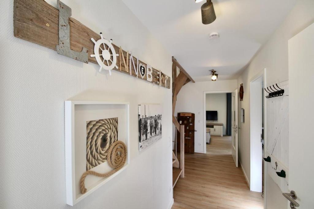 un couloir d'une maison avec des murs blancs et du parquet dans l'établissement Lönnegarden - Lönnebeker, à Kellenhusen