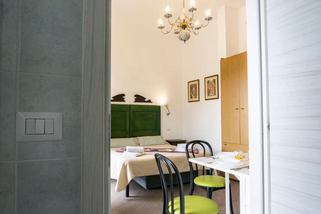 Habitación con cama, mesa y sillas. en Nonna Peppina Central Apartments, en Taormina