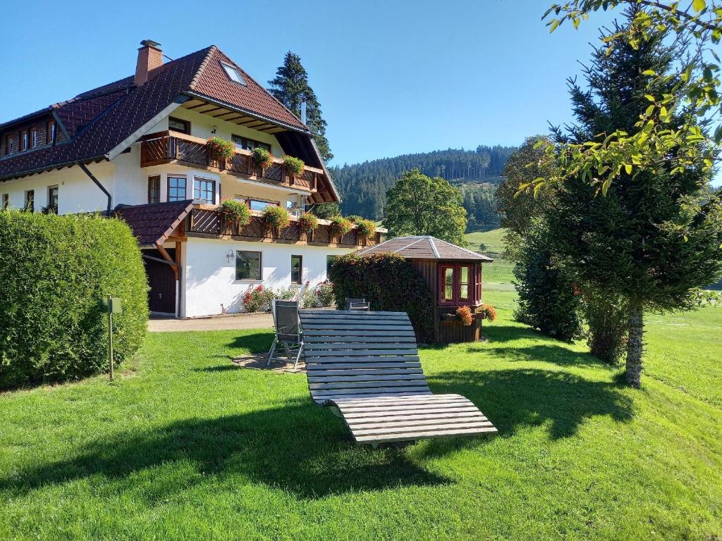 ein Haus mit einer Bank und einem Pavillon im Gras in der Unterkunft Ferienhaus Kaltenbach in Titisee-Neustadt