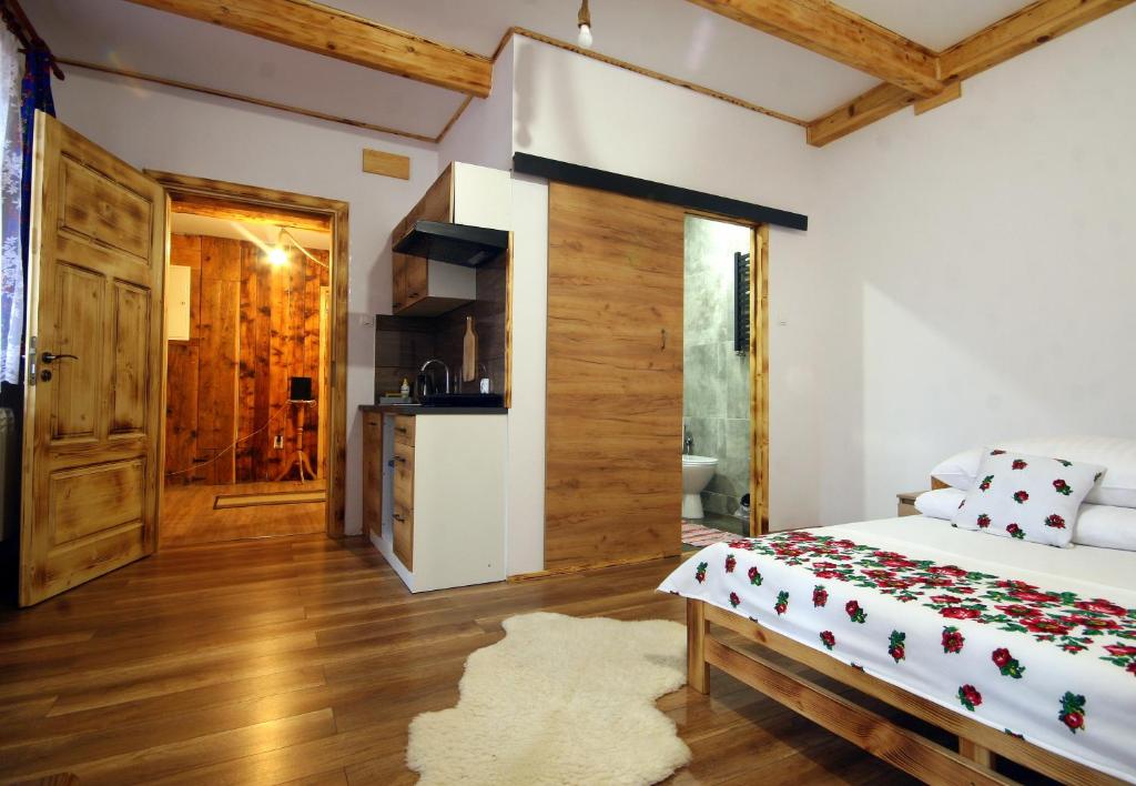 a bedroom with a bed and a kitchen at Pod Słowackim in Szczawnica