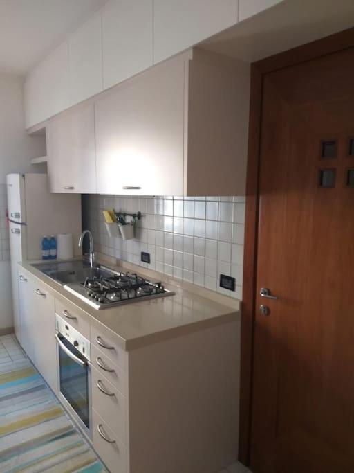 une cuisine avec des armoires blanches et un four à plaques de cuisson dans l'établissement Marghe Town, à Lazise