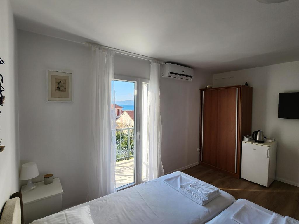 a bedroom with a bed and a large window at Apartmani Neva Supetar in Supetar