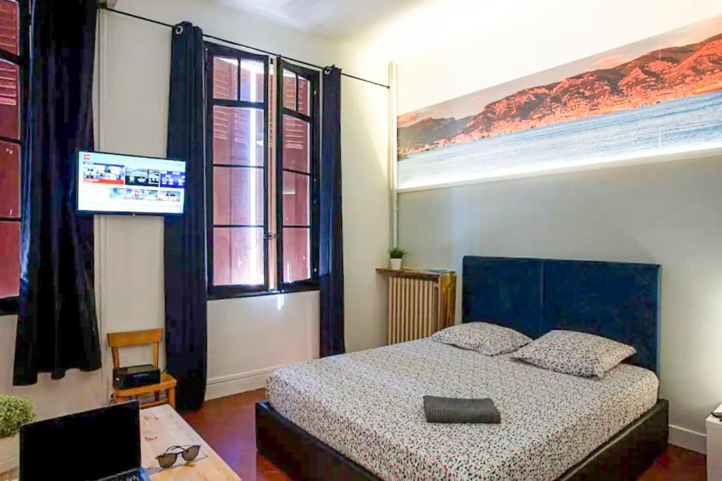 a bedroom with a bed and a television in it at #1 Toulon CENTRE AU CALME, LUMINEUX, STATIONNEMENT FACILE in Toulon