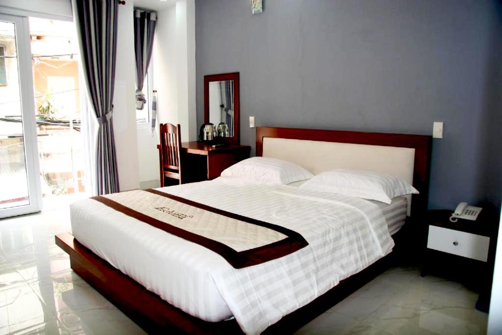 a bedroom with a large bed with a white blanket at YaYa Sai Gon Hotel Bui Vien Walking Street in Ho Chi Minh City
