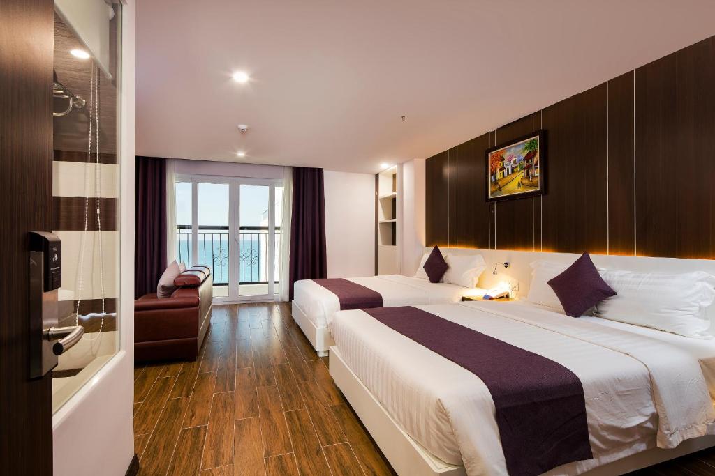 ein Hotelzimmer mit 2 Betten und einem Stuhl in der Unterkunft Morris Hotel Nha Trang in Nha Trang