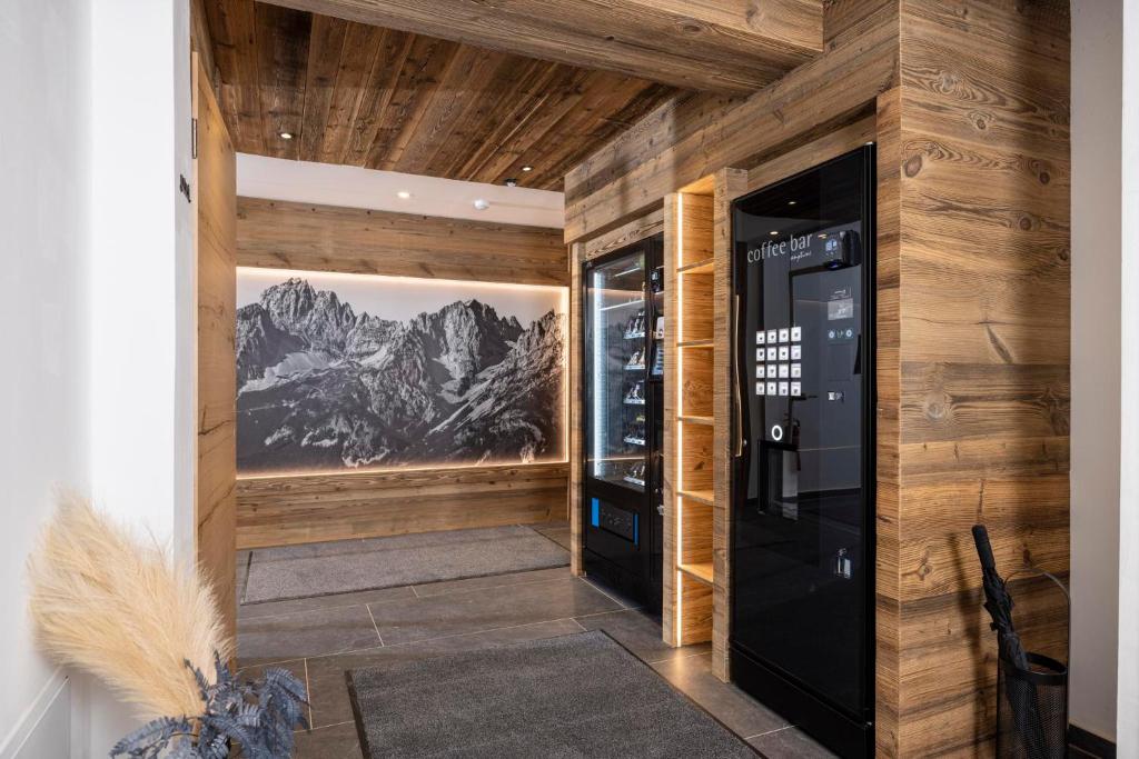 a room with wooden walls and a black vending machine at Apartments Austria in Söll