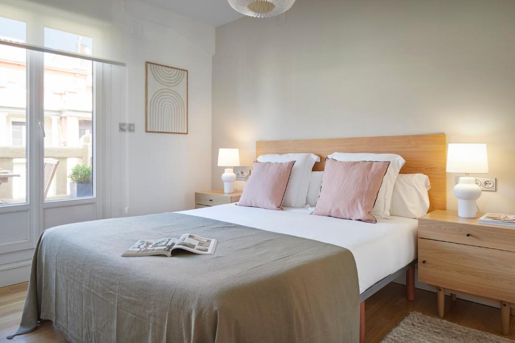 サン・セバスティアンにあるMirakruz Terrace by FeelFree Rentalsのベッドルーム(トレイ付きの白い大型ベッド1台付)