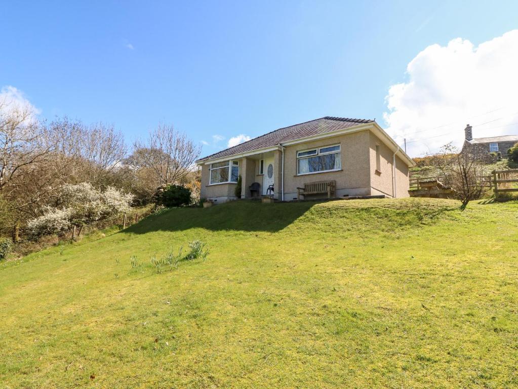 a house sitting on top of a grassy hill at Tirionfa in Talsarnau