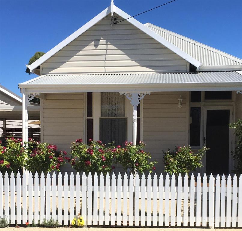 a white picket fence in front of a house at Rose Cottage in Bunbury