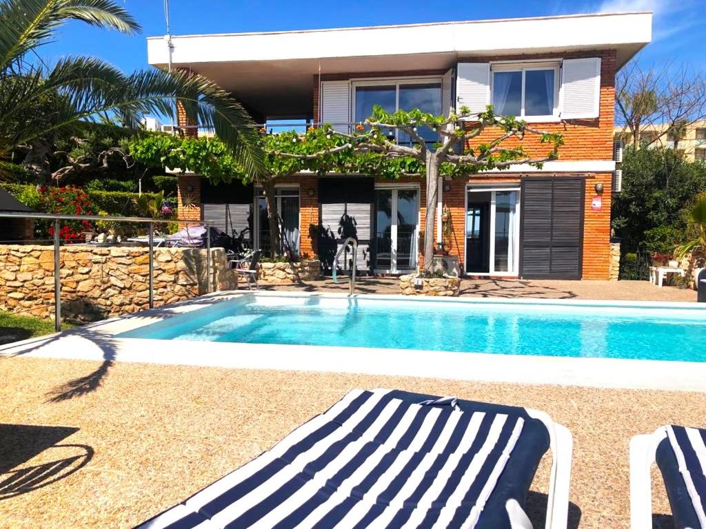 une maison avec une piscine en face d'une maison dans l'établissement Villa Playa, à L'Ametlla de Mar