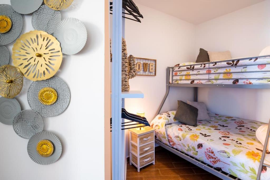 een slaapkamer met een stapelbed met hoeden aan de muur bij Coqueto apartamento con vistas in Torremolinos