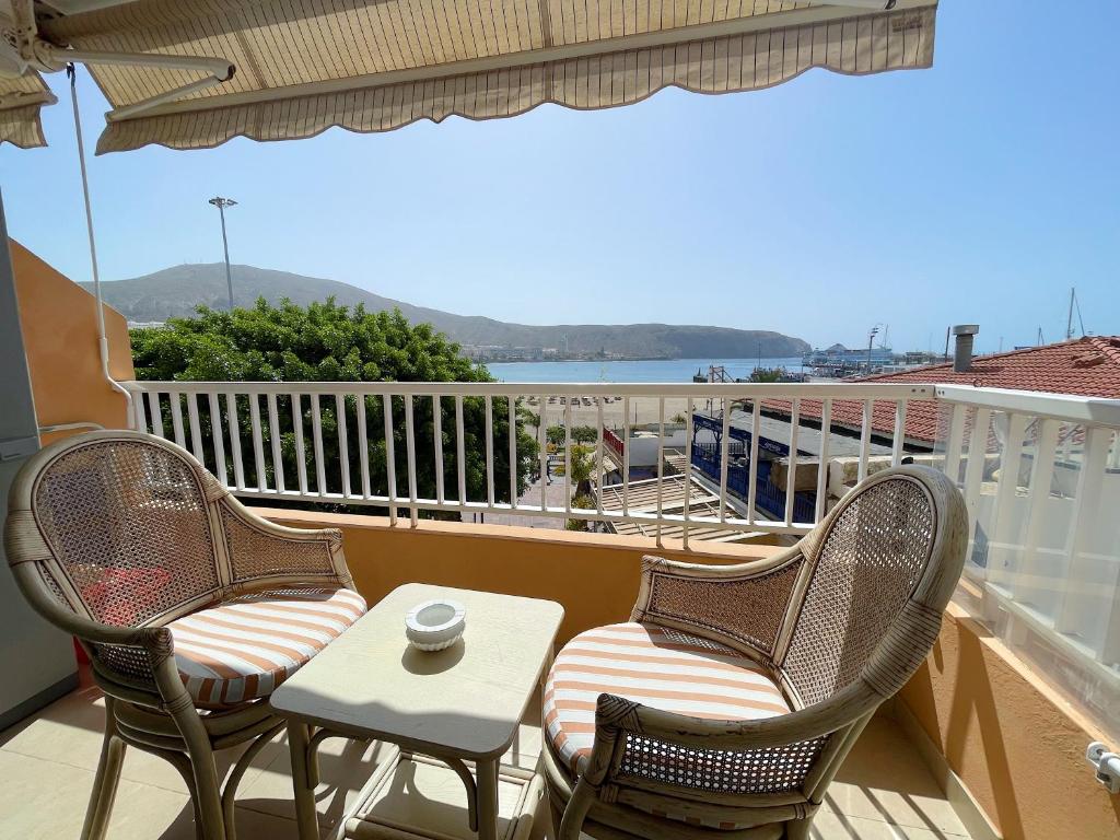 three chairs and a table on a balcony with a view at Edificio Arco in Los Cristianos
