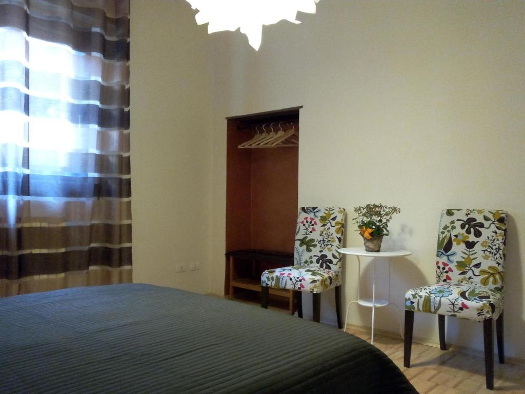 una camera da letto con due sedie, un letto e un tavolo di Ai Gabbiani a Verona