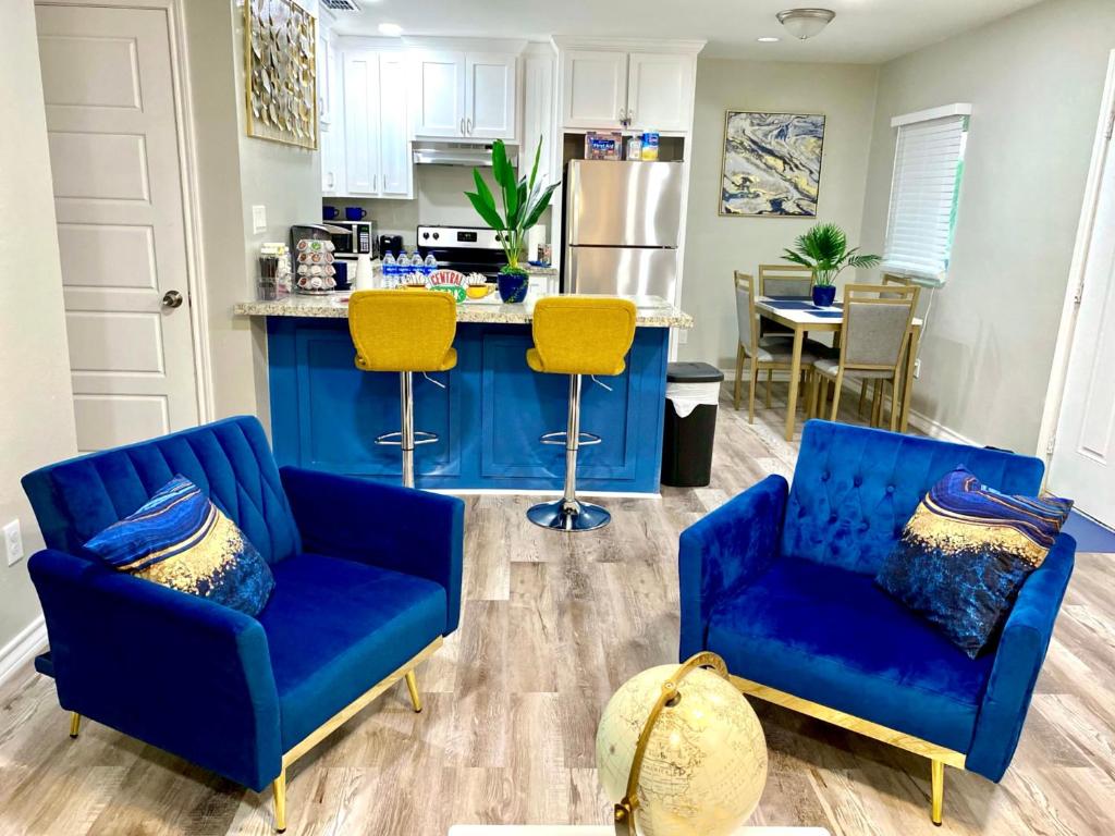a living room with two blue chairs and a kitchen at NEW! close to Downtown, Malls & Premium Outlets, with Balcony in Weslaco