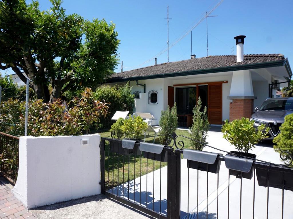 a house with a black fence in front of it at Beachside villa with private garden in Porto Santa Margherita di Caorle