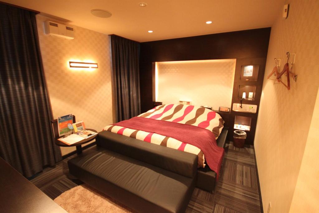 1 dormitorio con 1 cama con manta roja y blanca en ROOM龍ヶ崎 -Adult only-, en Ushiku