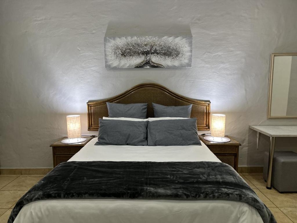 a bedroom with a large bed with two lamps on tables at Luxury and Comfort Hideaway 2 - Solar Powered in Pretoria