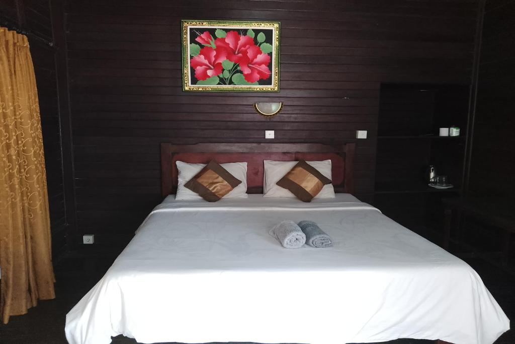 um quarto com uma grande cama branca e 2 almofadas em The Beach Huts Lembongan em Nusa Lembongan