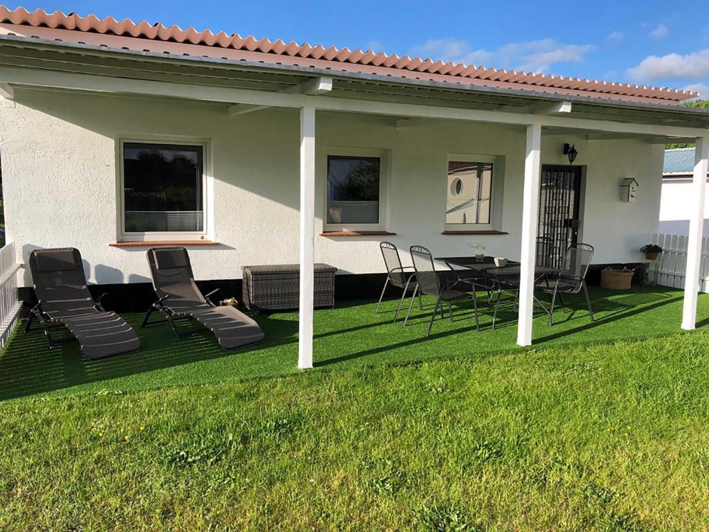 Bungalow Rudensicht في Freest: فناء مع كراسي وطاولة ومنزل