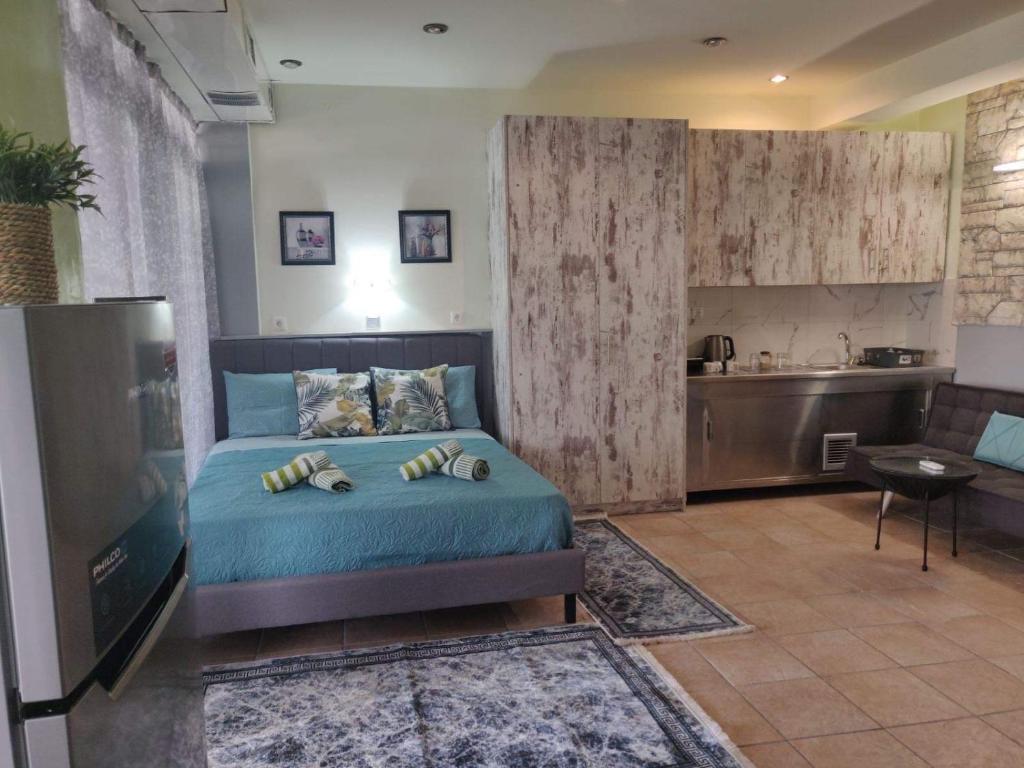 um quarto com uma cama azul e uma cozinha em Athens Victoria's Apartment em Atenas