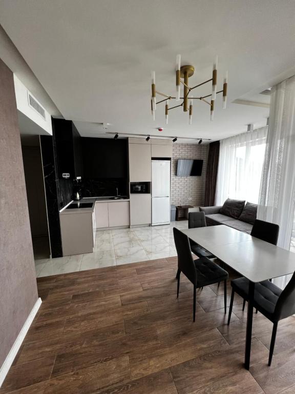a living room with a table and a kitchen at Апартаменти SunVI в ЖК Сонячний Квартал in Golubinoye