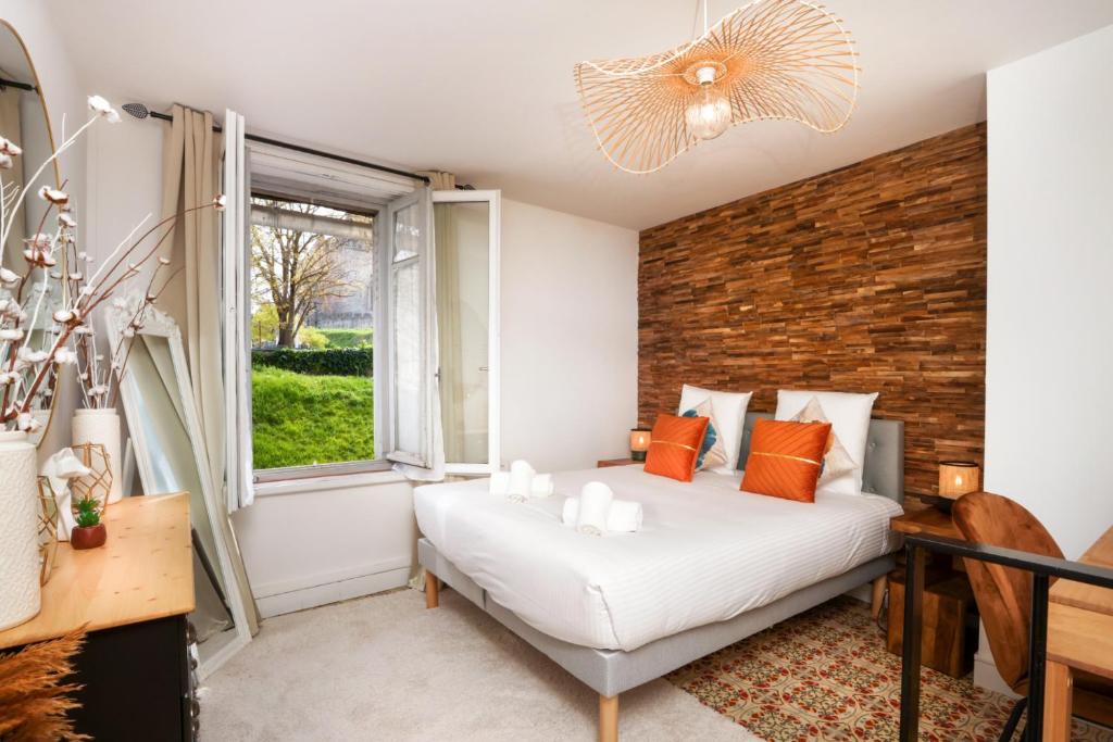 une chambre avec un lit et un mur de briques dans l'établissement Le Cocon de la Cité - Parking au Pied de La Cité, à Carcassonne