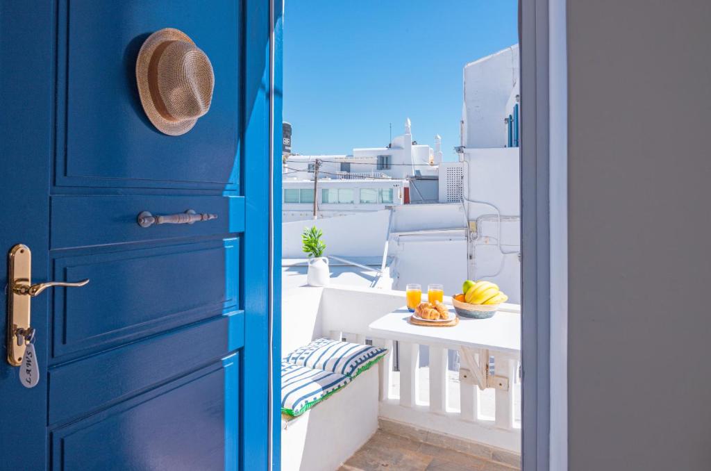 a blue door with a bowl of fruit on a balcony at Like a white seagull in Mykonos! in Mikonos