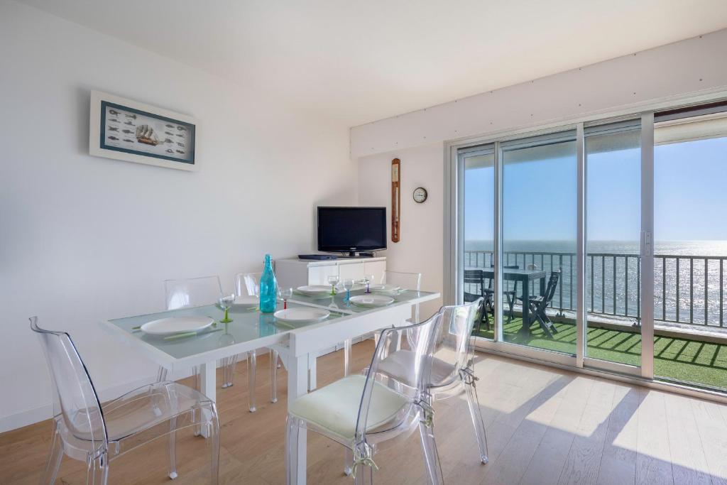 Un comedor con mesa y sillas y un balcón. en Magnifique vue mer à La Baule!, en La Baule-les-Pins