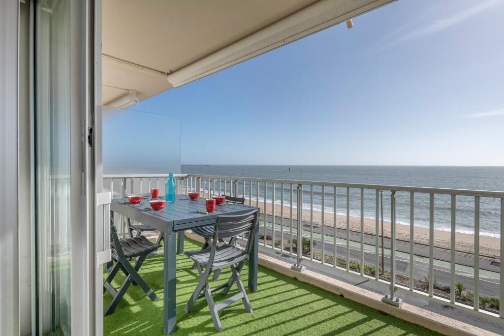 - un balcon avec une table et des chaises sur la plage dans l'établissement Magnifique vue mer à La Baule!, à La Baule