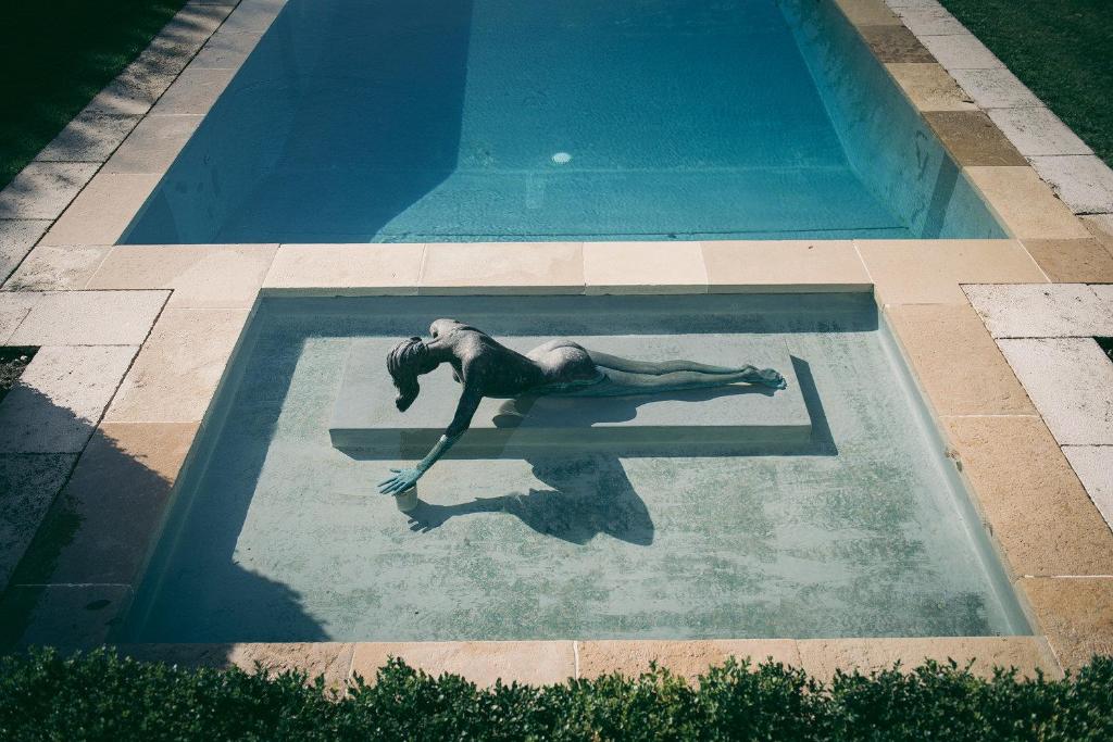 a woman floating in a swimming pool at Château du Tertre in Arsac