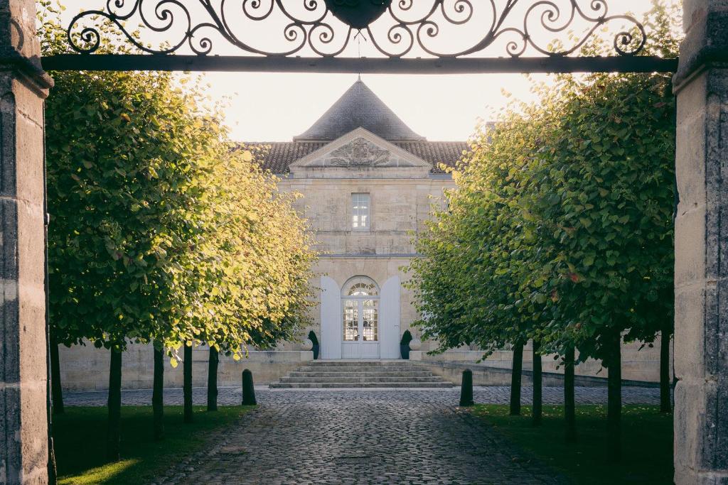 an archway leading to a building with a gate at Château du Tertre in Arsac
