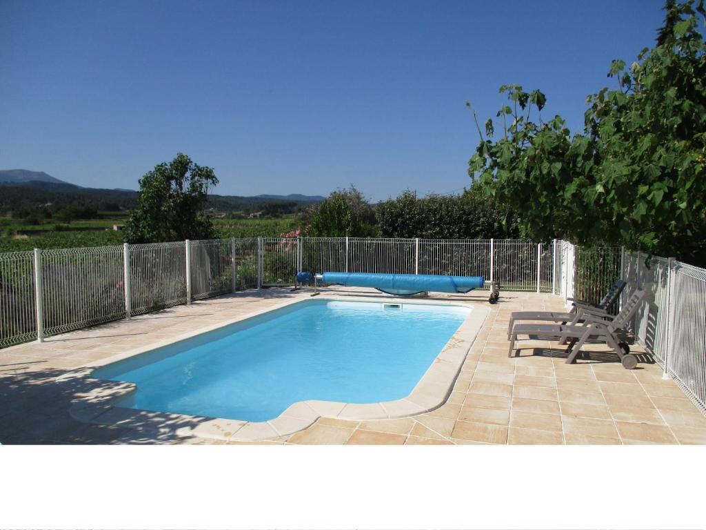 a swimming pool in a yard with a fence at Douceur Di'vignes - Appt avec piscine in Rosières