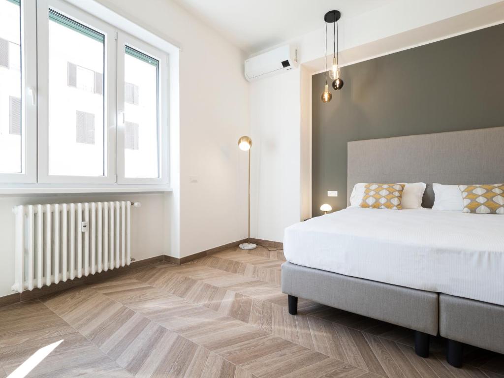 Un dormitorio con una cama blanca y una ventana. en Savoia Rooms Roma, en Roma