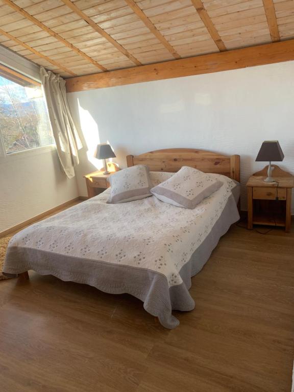 a bedroom with a bed with two pillows on it at Maison de village entre lac et montagnes in Loisin