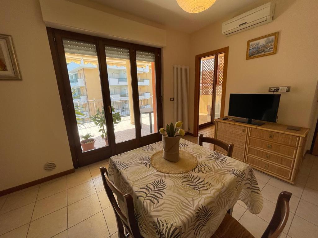 una sala da pranzo con tavolo, sedie e TV di Costa Adriatica Apartment a Tortoreto