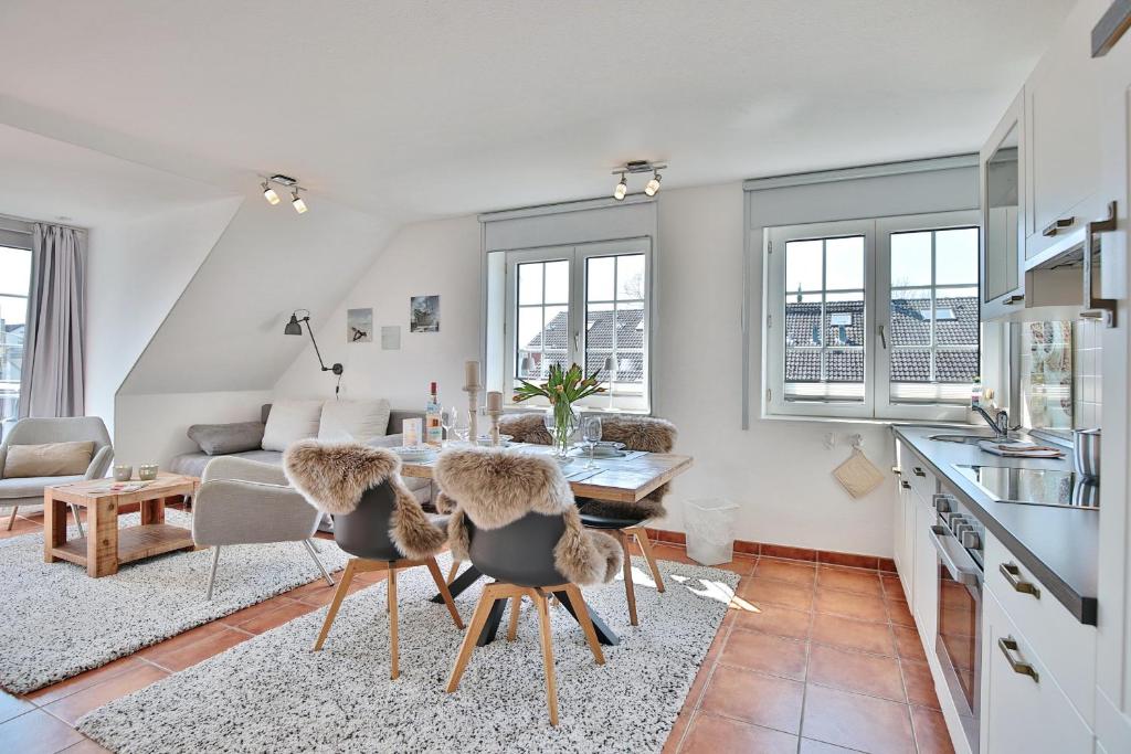 eine Küche und ein Wohnzimmer mit einem Tisch und Stühlen in der Unterkunft Haus am Falkenweg Haus am Falkenweg Appartement 6 in Scharbeutz