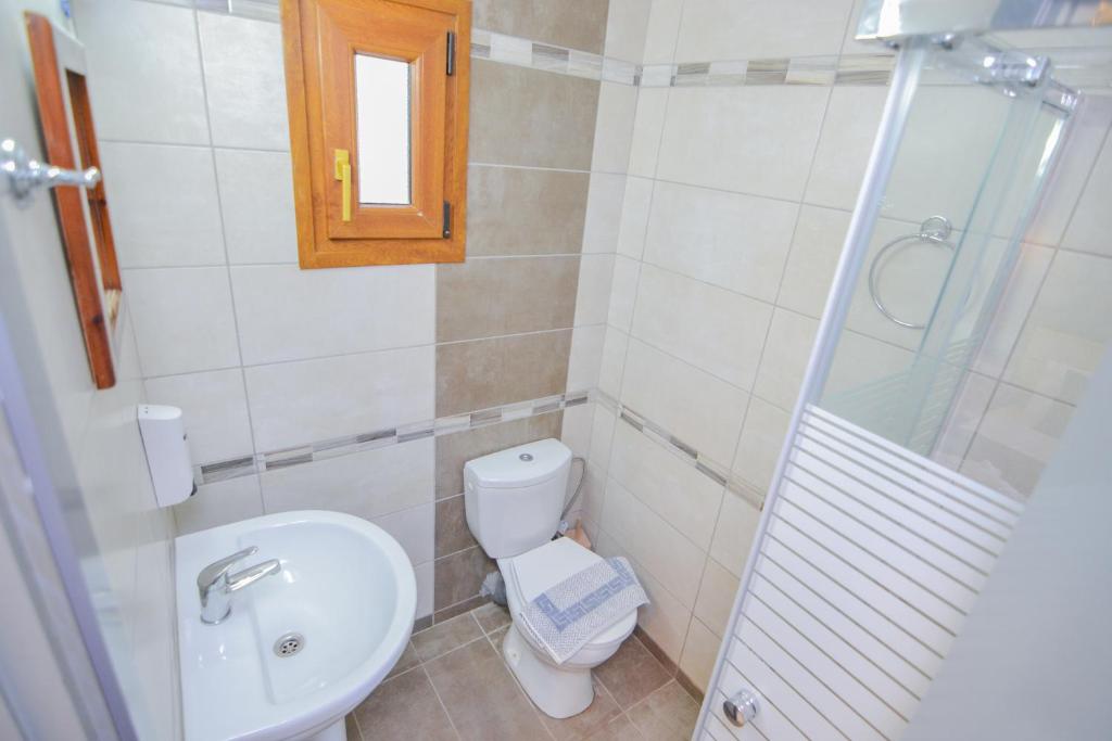 a bathroom with a toilet sink and a shower at Elafonisi Paradise with Parking, WiFi, - Walking Distance to the Beach in Elafonisi