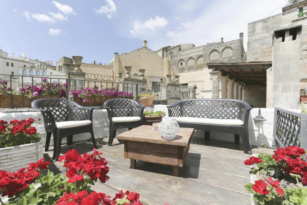 a patio with chairs and a table and flowers at Gradelle Pennino in Matera