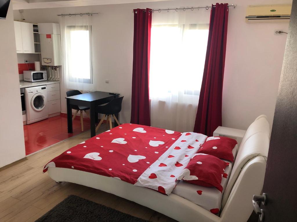 Un dormitorio con una cama con una manta roja con corazones en Jane House, en Bucarest