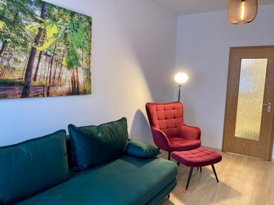 sala de estar con sofá y silla roja en Altes Uhrwerk, en Hasselfelde