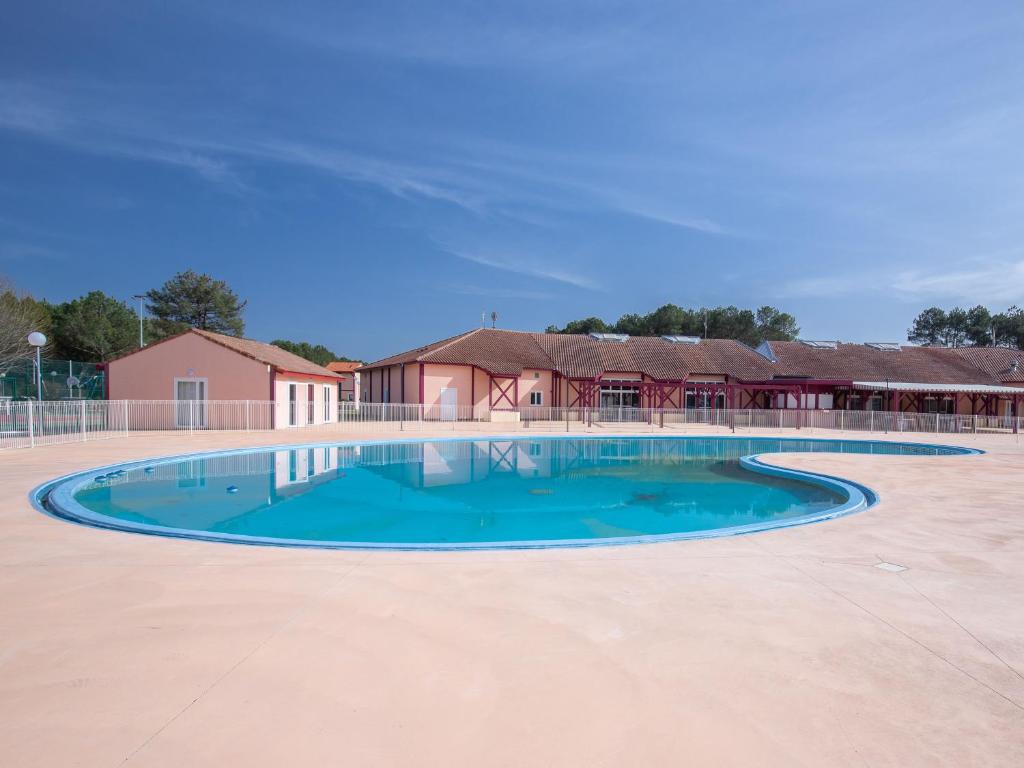 une piscine vide en face d'un bâtiment dans l'établissement Vacancéole - les villas du lac, à Soustons