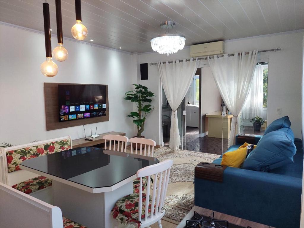 - un salon avec un canapé bleu et une table dans l'établissement Casa em Gramado, à Gramado