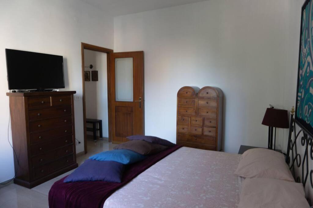 Schlafzimmer mit einem Bett und einem Flachbild-TV in der Unterkunft RQ Apartments in Bari