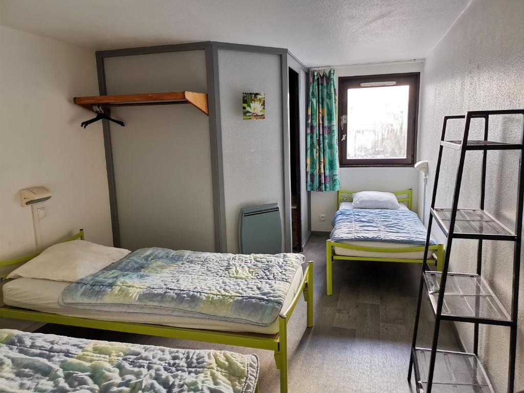 a room with two bunk beds and a window at Auberge de Jeunesse HI Boulogne-sur-Mer in Boulogne-sur-Mer
