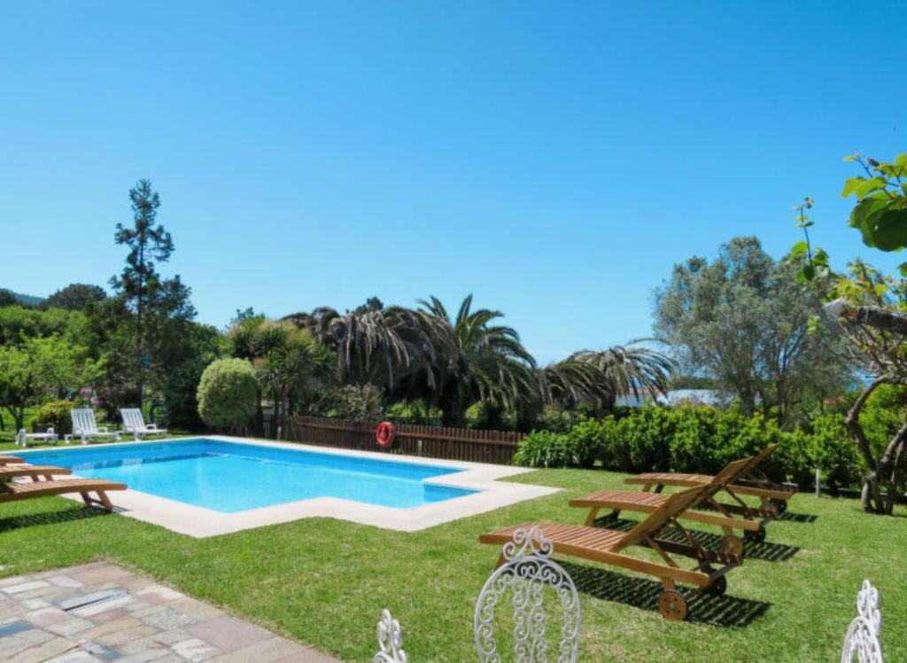 a backyard with a swimming pool and picnic tables at Fonte do Forno Villas in Afife